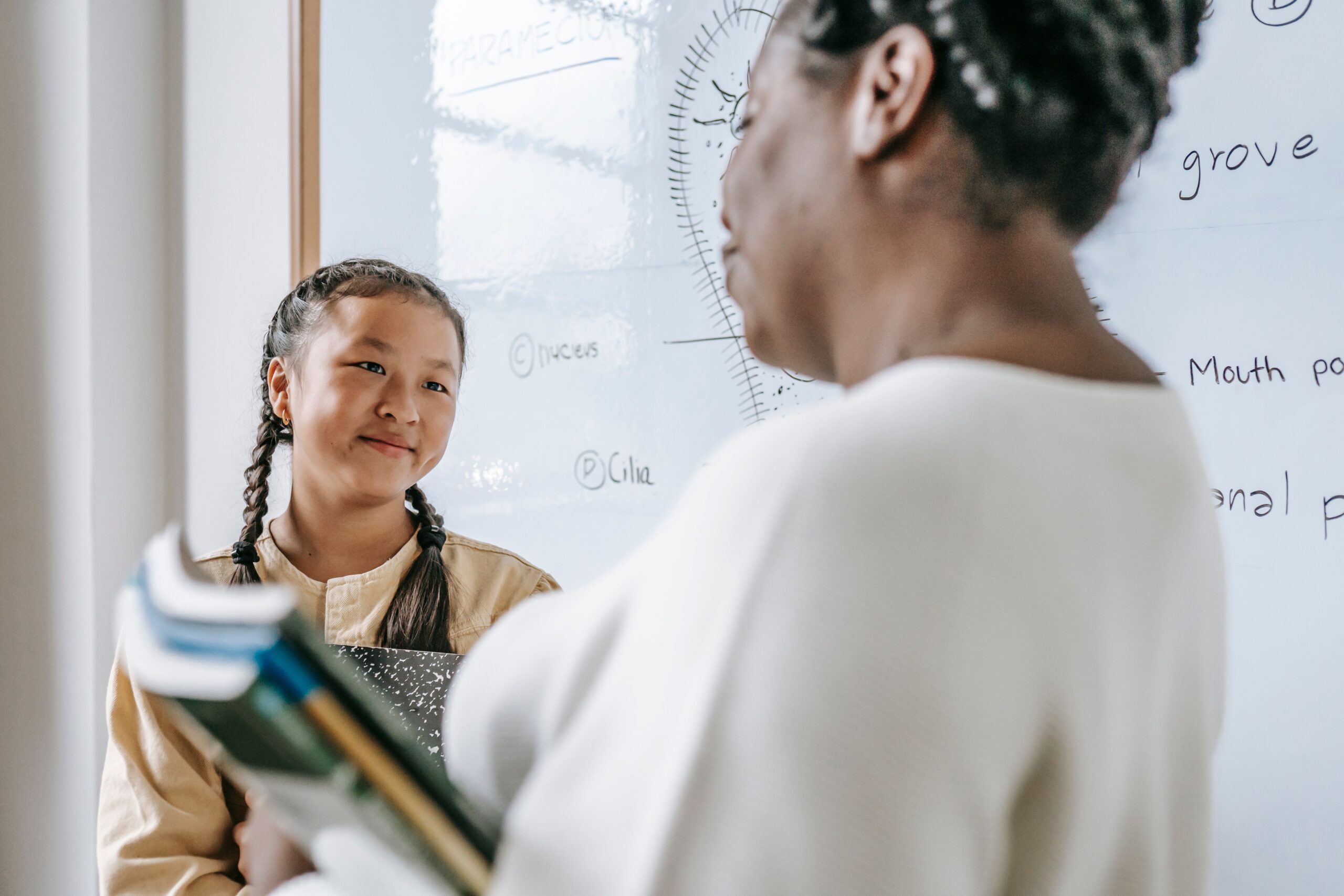 A teacher working closely with a young student in a classroom